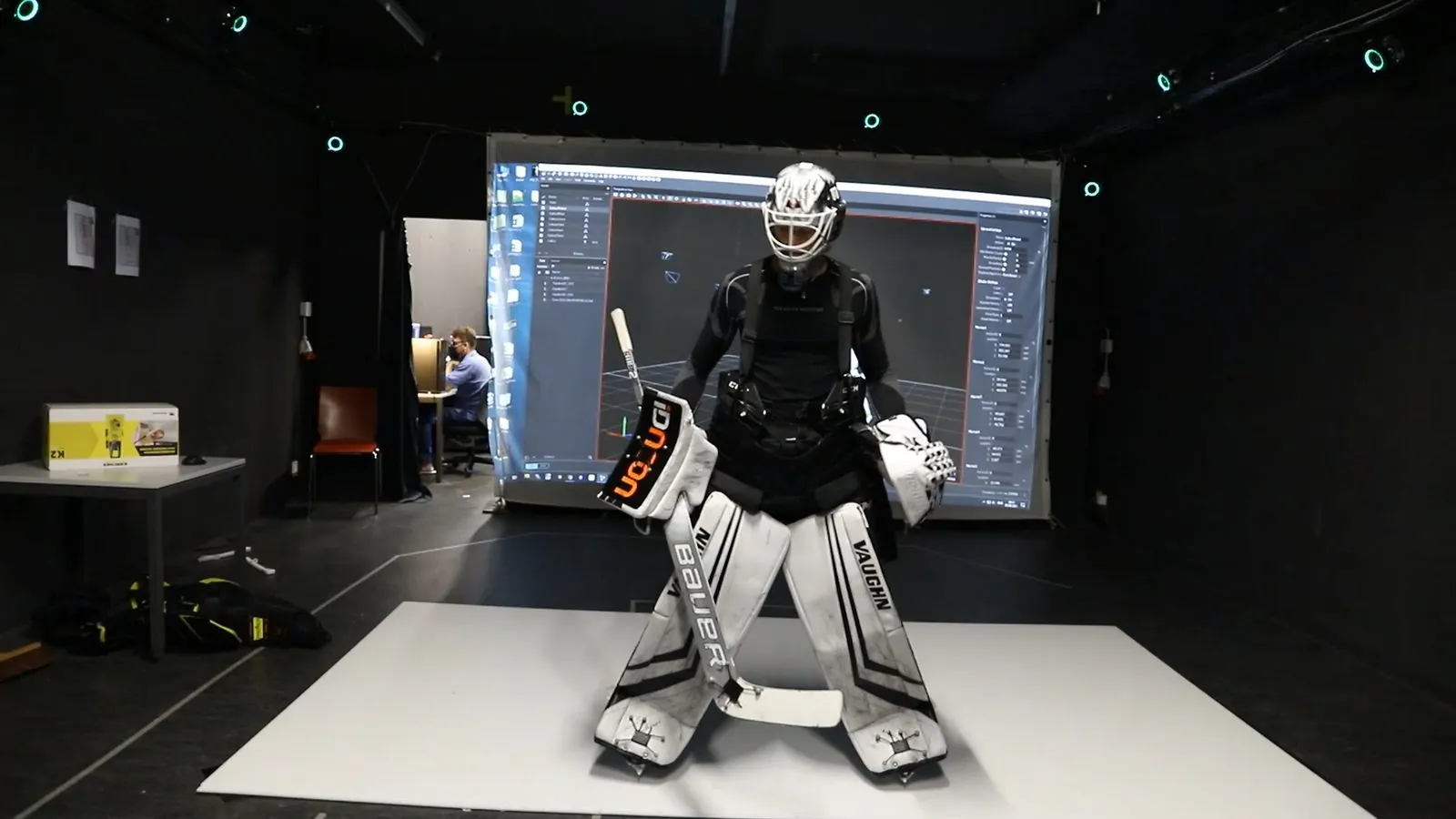 A goaltender in full gear and marker suit in the motion capture room.